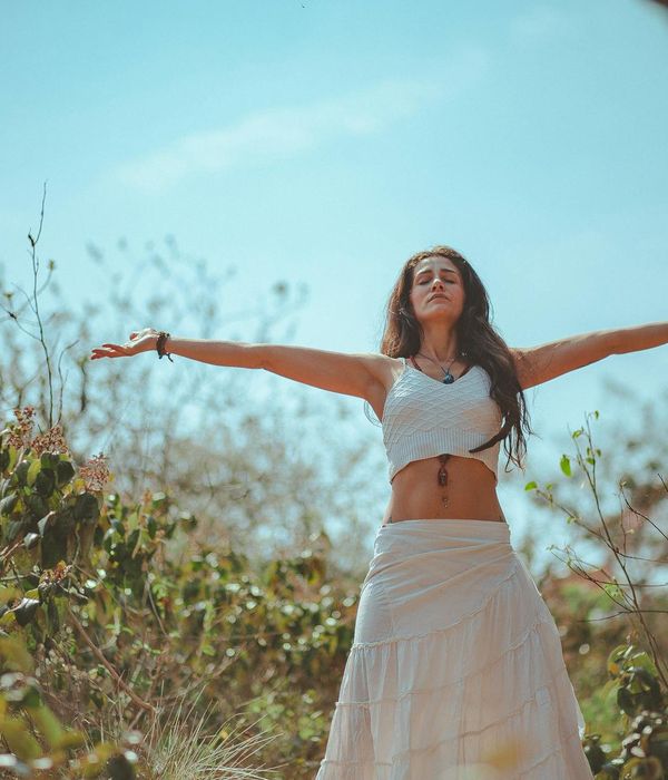 Woman in a peaceful yoga pose in a softly lit, calm environment.